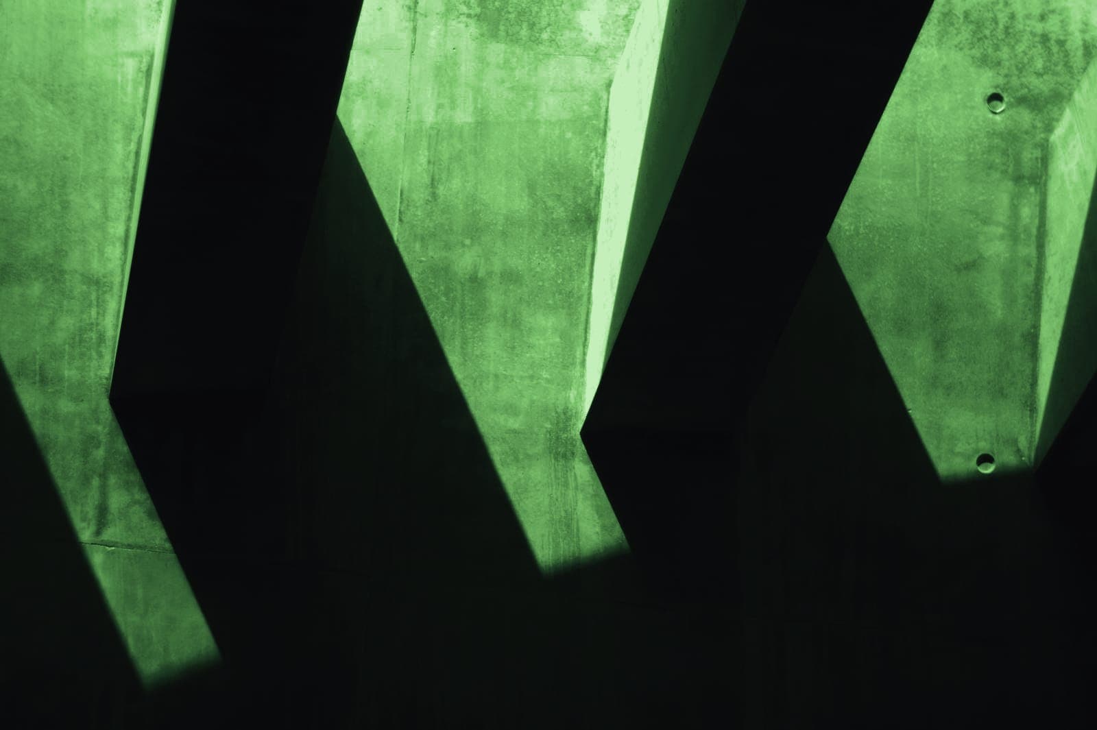 Hard shadows falling across a concrete wall